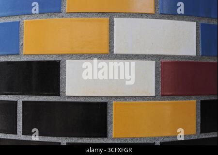 Ceramic tiles mosaic on a wall. Closeup photo of decorative, vintage, artistic tiles creating a geometric pattern. Stock Photo