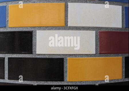 Ceramic tiles mosaic on a wall. Closeup photo of decorative, vintage, artistic tiles creating a geometric pattern. Stock Photo