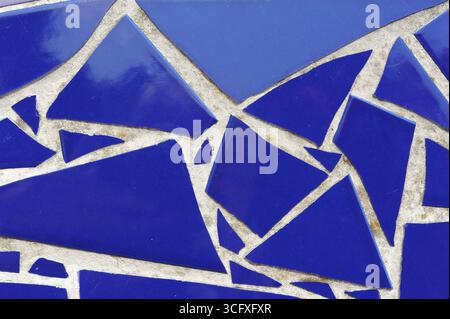 Ceramic tiles mosaic on a wall. Closeup photo of decorative, vintage, artistic tiles creating a geometric pattern. Stock Photo