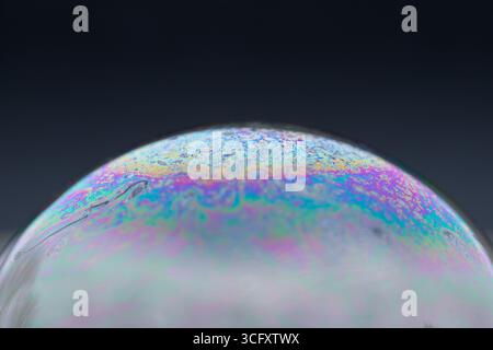 Frozen soap bubble on snow, winter magic of frozen soap bubble with beautiful ice crystals in perfect sphere on snow with blurred background Stock Photo