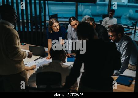 A diverse group of business people engage in a collaborative brainstorming session, focusing on teamwork and creativity. Stock Photo