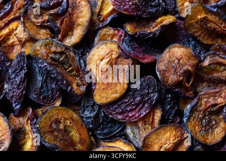 A detailed view of dried plums showing their wrinkled texture, rich hues, and organic appeal, ideal for concepts related to healthy eating, natural sn Stock Photo