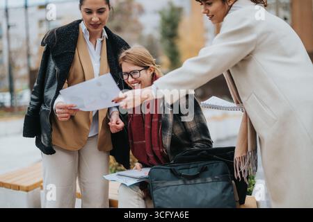 Three businesswomen collaborating on a project outdoors Stock Photo