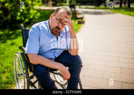 Portrait of man in wheelchair. He is worried and thoughtful. Stock Photo