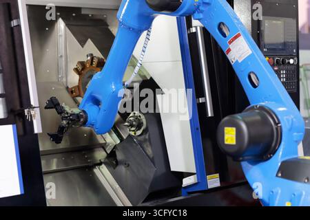 CNC lathe machine with collaborative robot. Work cell for automation of placing parts into CNC lathe machine with robotic arm. Selective focus. Stock Photo