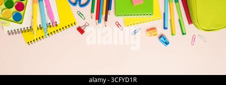 Back to school. School backpack with stationery on colored background. Web banner format. Stock Photo