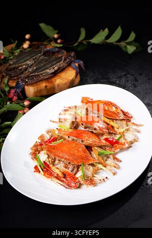 Oil-Fried Swimming Crab with Ginger and Chili on White Plate Stock Photo