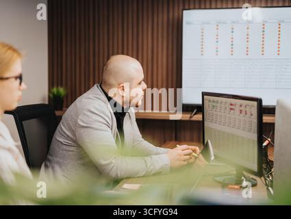 Office team analyzing project data during a business meeting Stock Photo