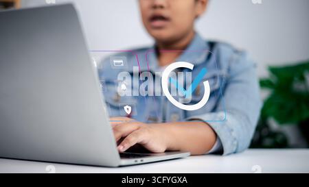 Person using laptop with checkmark, security, payment, and notification icons, symbolizing online approval, secure digital transactions, fintech, and Stock Photo