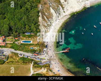 Aerial drone view of Lulworth Cove on the Jurassic Coast with tourists and boats Stock Photo