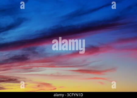Peaceful sunset sky scene with natural gradient hues and soft cloud shapes, perfect for calming visuals or background use. Stock Photo