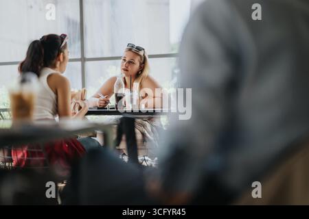 Two individuals having a focused conversation in a casual cafe setting Stock Photo