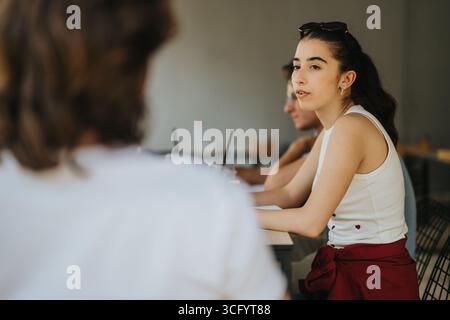 Focused students engaged in a thoughtful discussion during an outdoor meeting Stock Photo