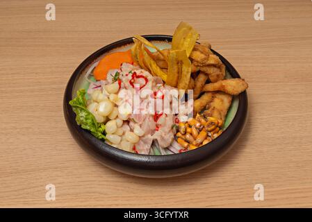 Gourmet presentation of ceviche in a tall glass, showcasing layers of marinated fish, purple sweet potato espuma, and a hint of yellow chili pepper Stock Photo