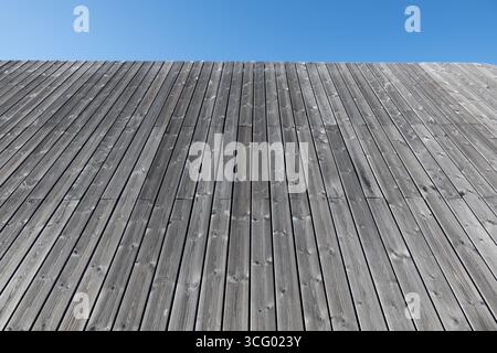Background surface of wooden planks in ashy grey color sloping to the sky. Stock Photo