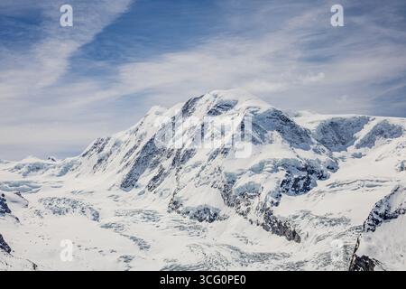 A breathtaking view of a snow-covered mountain range under a clear blue sky. Stock Photo