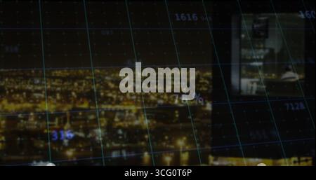 Displaying nighttime riverfront skyline through data grid overlay, with computer monitor inset Stock Photo