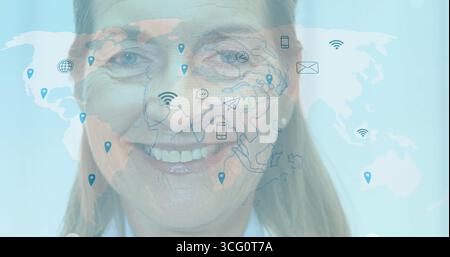 Smiling senior woman wearing blazer with world map overlay in studio, showing connectivity icons Stock Photo