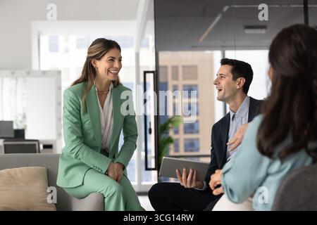 Three young professionals engaged in positive conversation Stock Photo