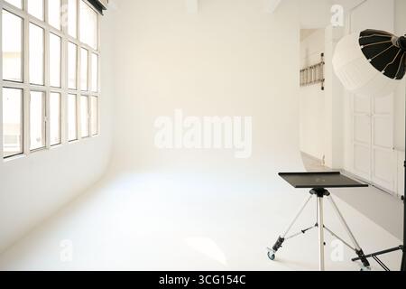 Empty photo studio with lighting equipment and large window Stock Photo