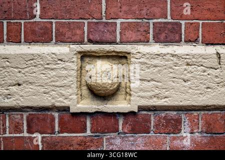 A textured wall background with red bricks and beige decorative element on a  building along Flinders Street in Melbourne, Australia. Stock Photo