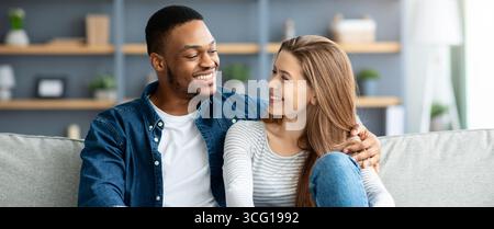 Portrait Of Loving Interracial Couple Relaxing Together At Home Stock Photo