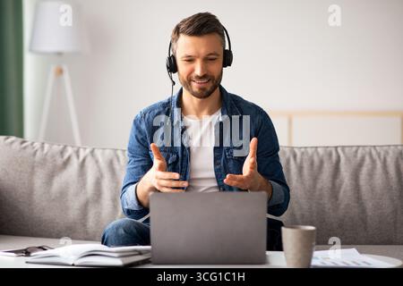 Happy man having video call with colleagues from home Stock Photo