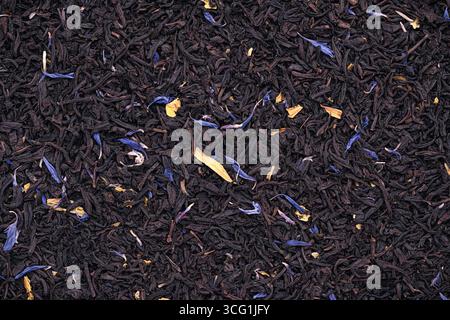Top view photography of dried Black tea, marigold petals, cornflower petals Stock Photo
