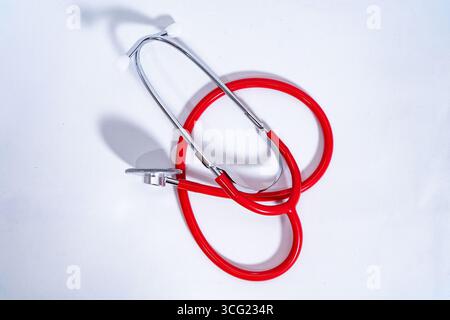 Red stethoscope on a white background, representing healthcare, medicine, and medical equipment Stock Photo
