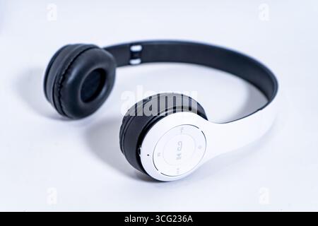 Stylish headphones with black earcups and a white headband are displayed on a plain white background, ready for listening to music or taking calls Stock Photo