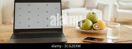 Modern Laptop Displaying Calibration Screen on Wooden Table in Bright Living Room Stock Photo