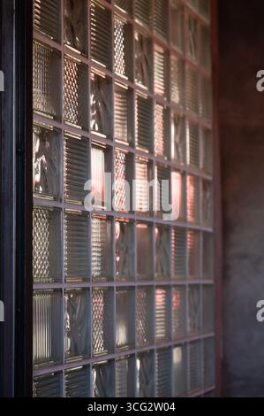 A mesmerizing view featuring a textured glass block wall that reflects light in a beautifully captivating manner Stock Photo