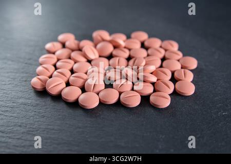 Much medical pills and drugs on the black stone background. Stock Photo