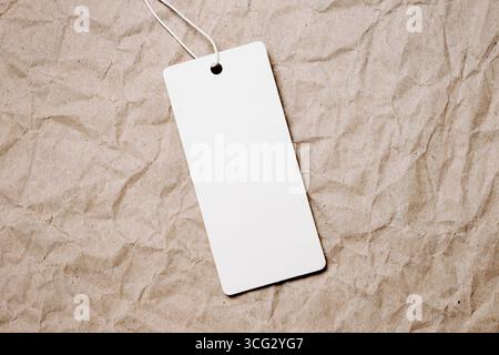 white tags, sale tag on vintage craft paper background. Mockup, copy space for text, top view Stock Photo