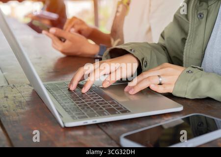Diversity in working team using internet on phones and digital tablet for teamwork at outside. Stock Photo
