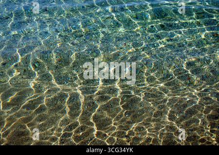 Transparent seawater surface. Sea water shining in the sun. Transparent water ripple background. Stock Photo