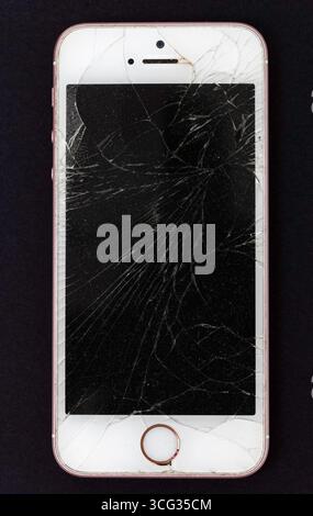 mobile phone, iphone, with cracked screen. Stock Photo