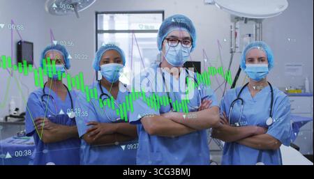 Standing medical team wearing scrubs masks and stethoscopes in surgical suite, with data overlay Stock Photo