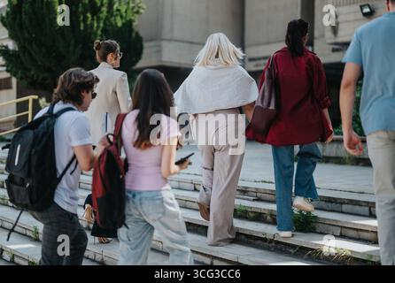 Group of students walking together on campus steps Stock Photo