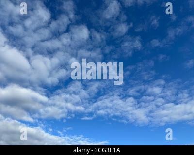 Beautiful blue sky filled with fluffy white clouds. Stock Photo