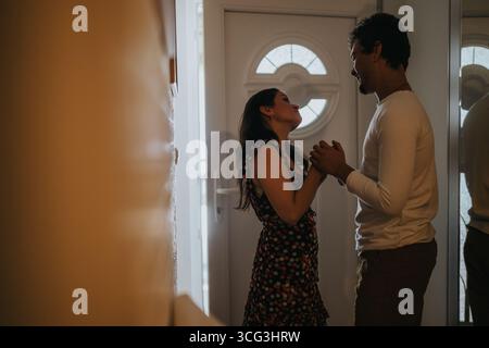 Couple sharing a moment of love and connection at home entrance Stock Photo