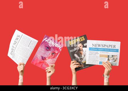 Female hands with different magazines and newspapers on red background Stock Photo