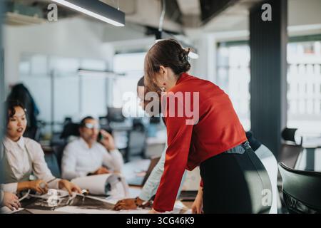 Diverse business team collaborates on project in modern office setting Stock Photo