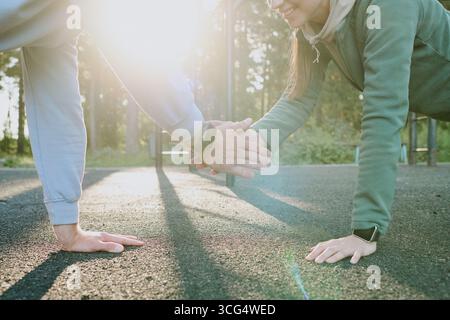 Young Adult Caucasian Woman and Man Doing Outdoor Push Ups and Smiling Stock Photo