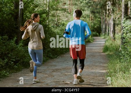 Young Caucasian Woman and Young Caucasian Man Jogging Together Outdoors Stock Photo