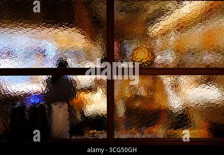 view of restaurant through textured glass window Stock Photo