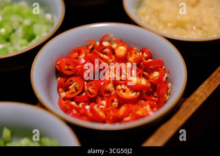 a bowl of sliced red chili peppers Stock Photo