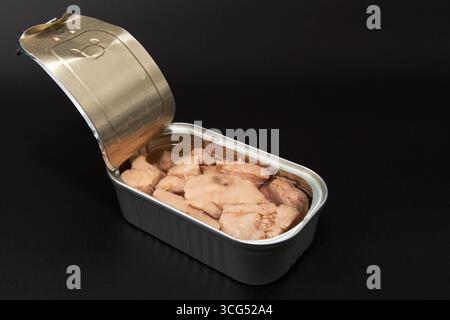 Open tin can with cod liver in oil on dark background. Concept of canned seafood healthy diet protein food and omega 3 nutrition Stock Photo