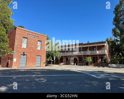 The red-brick Masonic Hall and Fallon Hotel stand across from each other on a sunny day Stock Photo