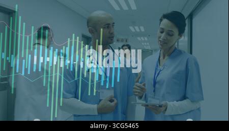 Reviewing adult female and male medical staff consulting tablet data in hospital corridor, teamwork Stock Photo